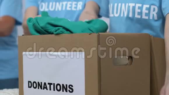 志愿者把衣服装在盒子里接受捐赠低收入家庭援助视频的预览图