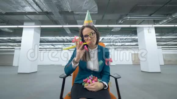 悲伤的女经理坐在生日帽里扔纸屑视频的预览图
