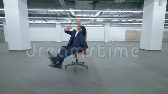 一个穿西装的人坐在滚动的椅子上胡闹视频的预览图