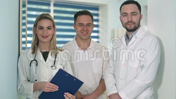 两名男医生和女医生带着听诊器对着镜头微笑视频的预览图