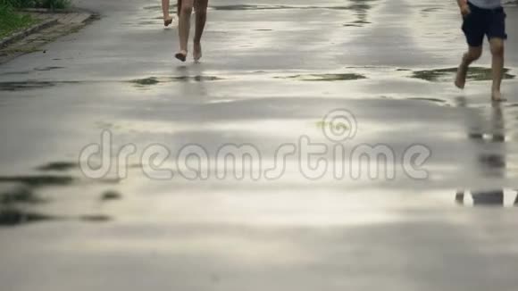 雨后赤脚的孩子在水坑里奔跑夏令营娱乐视频的预览图