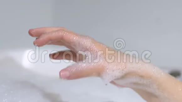女性使用天然海绵在浴缸有机护肤家庭水疗中心洗手视频的预览图