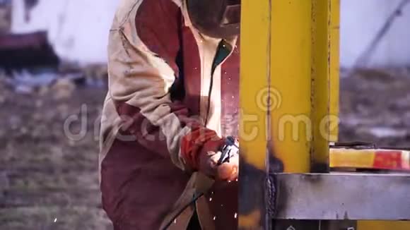 人穿红色和灰色长袍焊接黄色金属施工时戴安全手套和安全面罩安全第一视频的预览图
