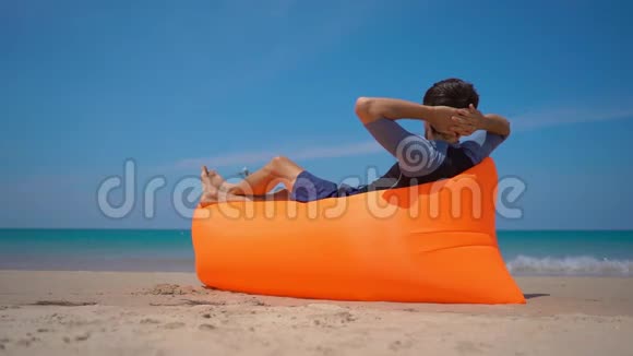 在热带海滩上躺在充气沙发上观看飞机着陆的快乐游客的超景色镜头视频的预览图