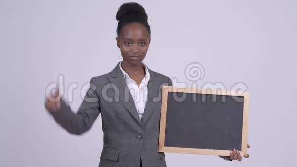 年轻悲伤的非洲女商人拿着黑板竖起大拇指视频的预览图