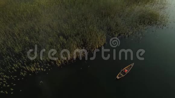 湖边有渔夫的木船上景绕着船飞行视频的预览图