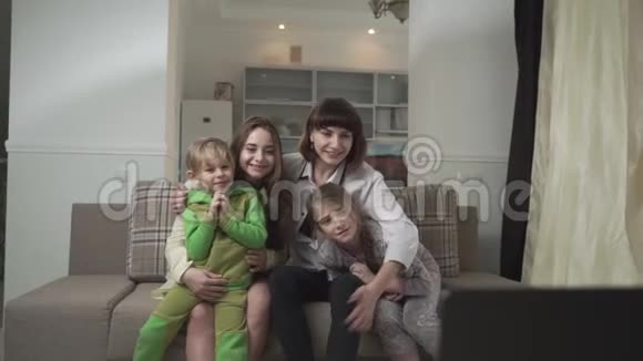 幸福的家庭支持坐在沙发上的足球队妈妈和儿子拍打膝盖家庭节日快乐视频的预览图
