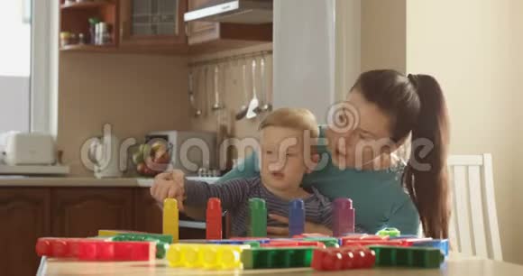 母亲教小男孩如何使用彩色块计数和使用教育游戏视频的预览图