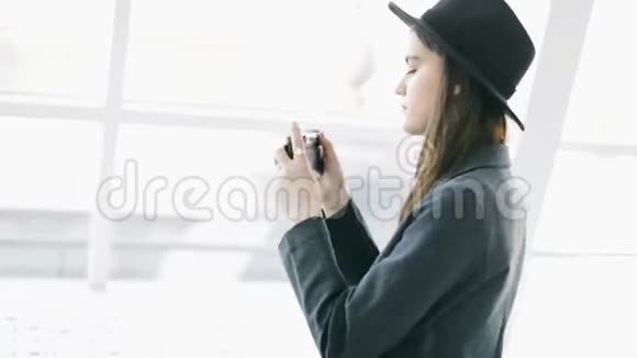 拍照时尚漂亮的女孩拿着复古风格的凸轮抓住时机录像片段视频的预览图