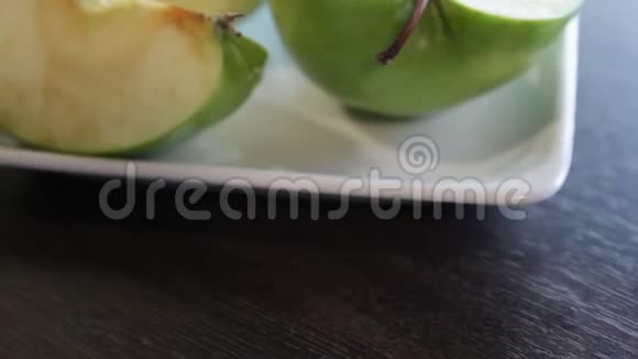 绿色苹果切片放在方形的白色盘子里摄像机绕着这个向左移动特写镜头宏观经济视频的预览图