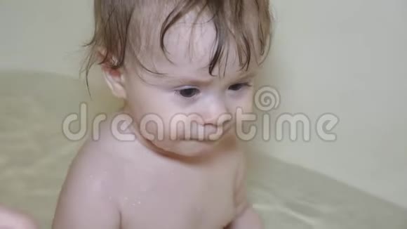小宝宝在浴室里用干净的水啃玩具鸭子和揉眼睛视频的预览图