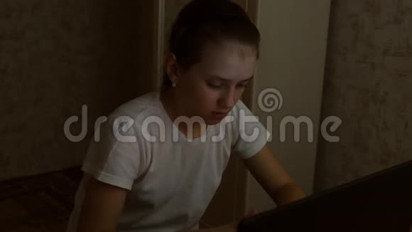女孩在深夜键盘上输入文本青少年用笔记本电脑在社交网络上写信儿童吸取经验教训视频的预览图