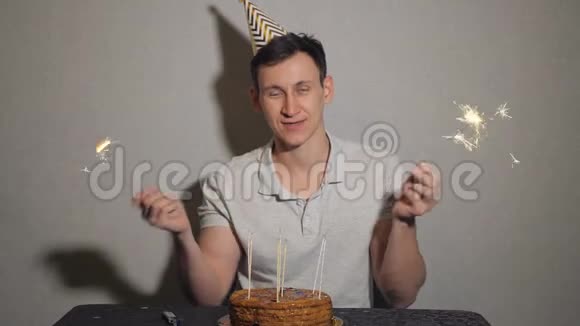 孤独的快乐男人拿着蛋糕和蜡烛拿着火花视频的预览图