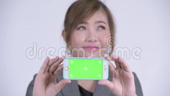 年轻快乐的亚洲女商人一边看手机一边思考视频的预览图