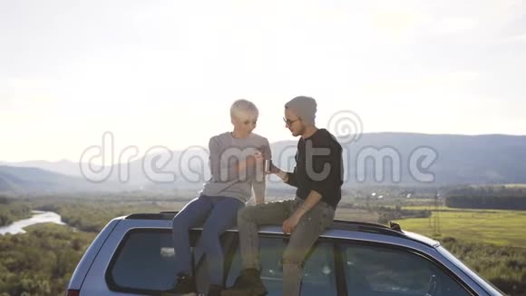 年轻英俊的男人和女人喝茶在山上背景上放松视频的预览图
