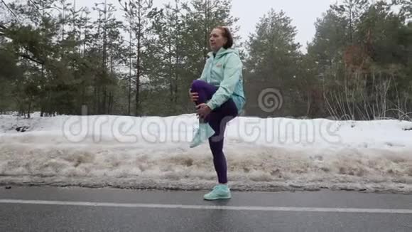 老白种人女人在雪地冬季公园跑步前热身侧面射击视频的预览图