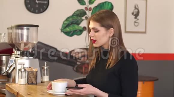 年轻时尚的女孩博主在咖啡馆里拍了一杯卡布奇诺的照片视频的预览图