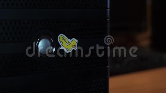 手手指按下桌子背景上的系统单元盒子电脑的启动按钮上面有黄色的视频的预览图