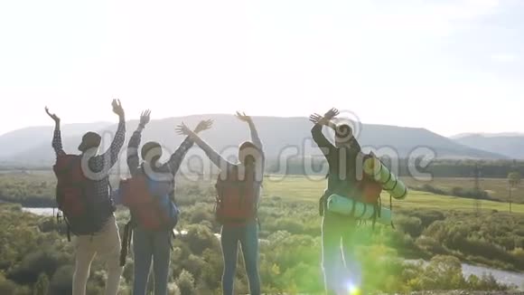 两对年轻的旅行者在山顶上挥手视频的预览图