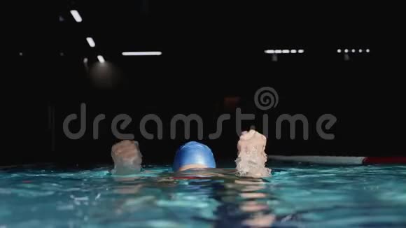 游泳运动员在游泳池里跳起来举起手臂欢呼视频的预览图