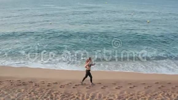 海滩上适合女子跑步训练的无人视野视频的预览图