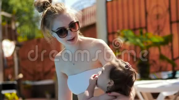 年轻的母女在游泳池后吃了一颗李子视频的预览图