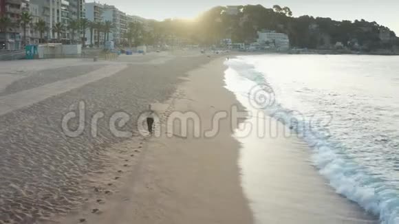 穿着运动的女性在海滩上奔跑的无人视野视频的预览图