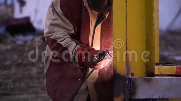 人穿红色和灰色长袍焊接黄色金属施工时戴安全手套和安全面罩安全第一视频的预览图
