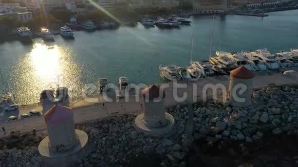 空中中世纪风车在曼德拉基港在日落盐的光线在多德科尼斯岛罗兹希腊视频的预览图