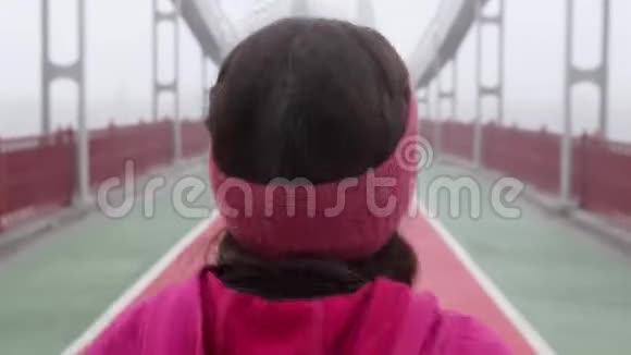 年轻胖乎乎的白种人女孩在桥上奔跑后面跟着射击紫色服装视频的预览图