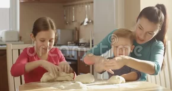 厨房里快乐的家庭烹饪与面团和配料视频的预览图