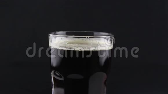 酒保把黑啤酒从瓶子里倒入玻璃杯里一个人把一杯黑啤酒装满视频的预览图
