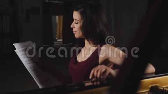 女钢琴家坐在钢琴旁边考虑音乐音符视频的预览图