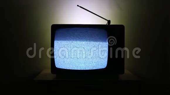 一台老式电视的视频在黑暗的背景上被隔离屏幕上没有信号和灰度噪声的影响视频的预览图
