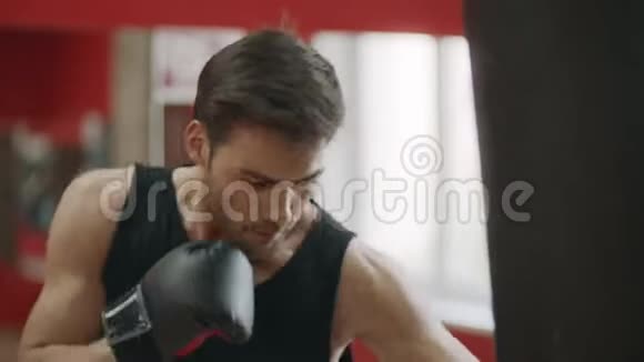 拳手男子训练打在战斗俱乐部的战斗袋上视频的预览图