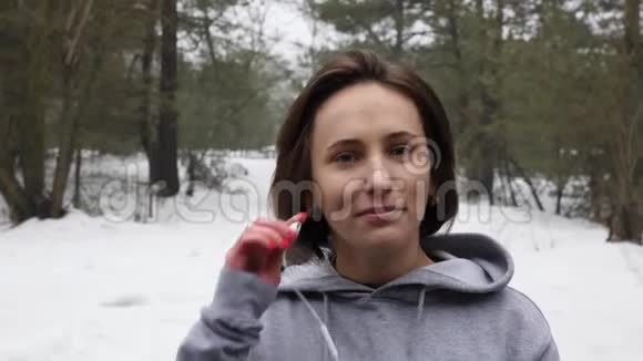 年轻迷人的白人女孩在冬天在雪地公园跑步之前先戴上耳机近距离前射视频的预览图