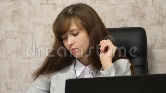 年轻的女企业家在笔记本电脑后面工作电脑上的在线商务对话坐在椅子上的女孩视频的预览图