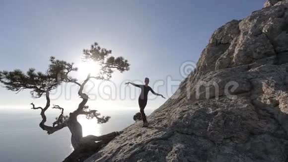 年轻女子在山上跳舞跑步在海面上美丽的景色中登上顶峰的女士视频的预览图