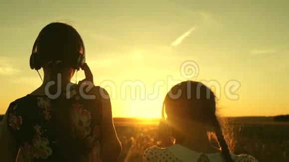 姐妹们一起听音乐快乐的少女们在美丽的夕阳下听音乐跳舞视频的预览图