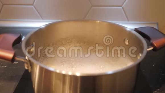 在家里的厨房炉子上用不锈钢锅煮水视频的预览图