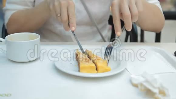 女人在餐馆里用叉子吃美味的蛋糕视频的预览图