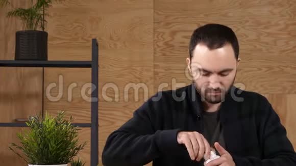 年轻的商人坐在笔记本电脑前工作时吃药视频的预览图