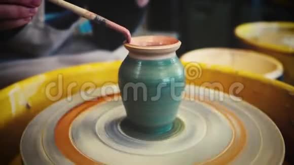 女陶工在陶工车轮上画一个粘土花瓶手工陶器里面视频的预览图