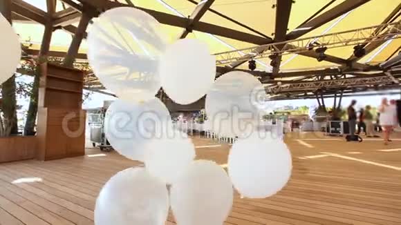一群白色氦气球在风中摇摇晃晃视频的预览图