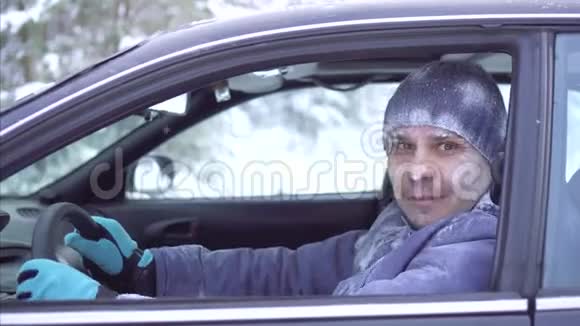 冬天在车里呆着一个快乐的冻人微笑着伸出大拇指视频的预览图