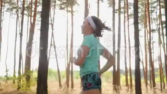 穿着运动服的女孩在森林里慢跑视频的预览图