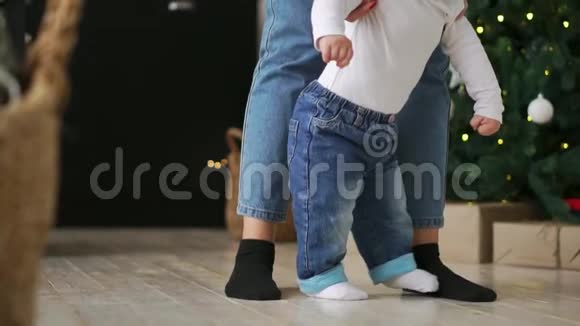 在长长的走廊里妈妈和宝宝脚在木地板上行走视频的预览图