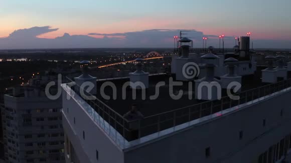 傍晚日落背景下站在屋顶高楼上的无人观景人视频的预览图