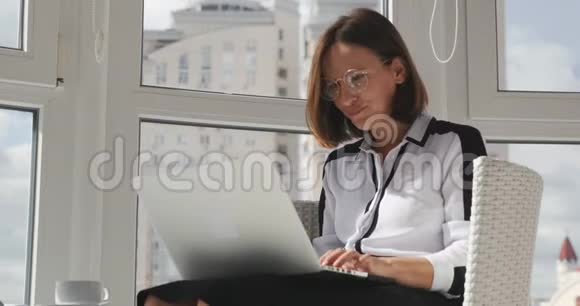 年轻漂亮的黑发商业女人戴着眼镜对她的工作不满意从事笔记本电脑工作的高加索女性办公室雇员视频的预览图