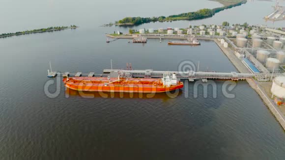 一艘巨大的红色油轮停泊着石油装载石油产品并向大洋彼岸的遥远国家出口视频的预览图